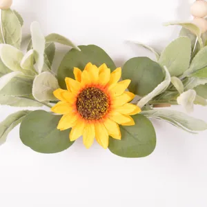 Close up detail of artificial sunflower and eucalyptus leaf wreath for farmhouse wall decor.