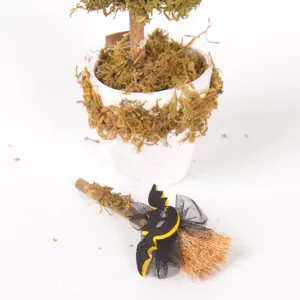 Detailansicht der Halloween Moos Topfpflanze mit Mini Hexenbesen und Fledermaus Deko für Tisch.