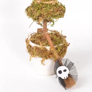 Detailaufnahme der Halloween Moos Topfpflanze mit Mini Hexenbesen und Totenkopf Deko.