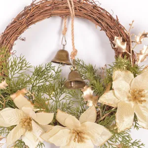 Primo piano dettagliato della ghirlanda natalizia decorativa con fogliame finto e fiori dorati.