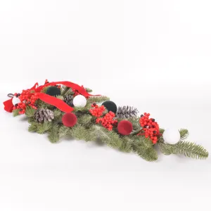 Christmas teardrop swag detail showing flocked pine branches, red berries and velvet balls.