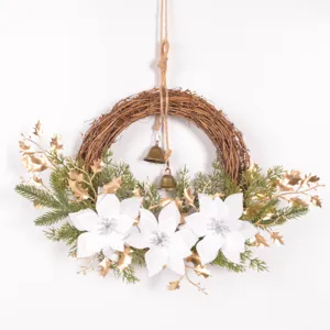 Dettaglio ravvicinato della ghirlanda natalizia decorativa con poinsettia bianche e campanelle.