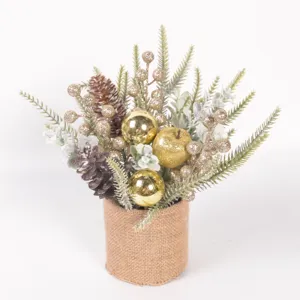 Detailed shot of miniature Christmas tree potted plant with pine cones, golden berries and burlap.