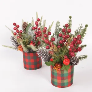 Christmas desktop decoration mini potted plant close up with pine branches and red berries.