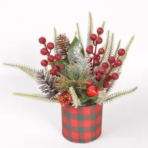 Christmas desktop potted plant decoration with artificial pine branches and red berries.