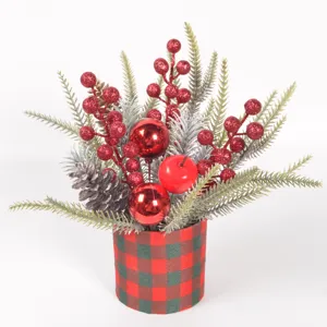 Detail view of Christmas artificial pine branches, glitter red berries, and plaid pot decor.