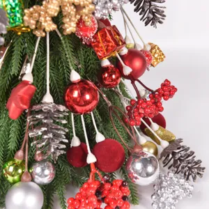 Close-up of Christmas tree branches with red and silver baubles, pine cones, and berries.