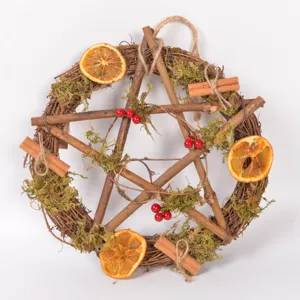 Rustic twig pentagram wreath with dried orange slices moss and cinnamon for Christmas decor.