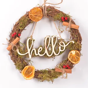 Christmas wooden letter rattan wreath with dried orange slices, moss, and holiday berries.