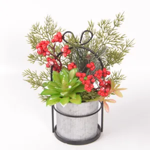Christmas artificial succulent and red berry potted plant with iron bow frame detail.