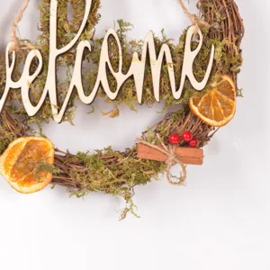 Rustic wooden welcome wreath with moss dried orange slices and berries for front door decor