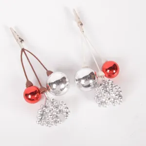 Close up of Christmas decorative clip detail featuring red balls, silver balls and berry clusters.