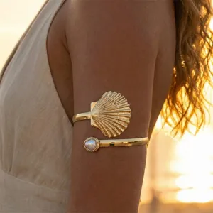 Vista detallada del brazalete de brazo dorado con concha y perla, estilo vacacional.
