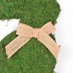 Primer plano detallado de decoración de conejo de pascua de musgo con lazo de yute.