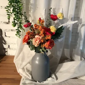 Detailed shot of an autumn-toned artificial flower bouquet in a grey vase, perfect for home decor.