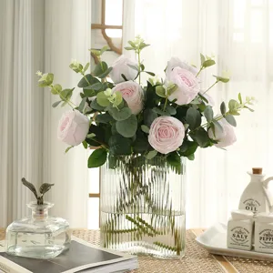 Artificial pink rose bouquet with eucalyptus leaves in clear glass vase for home decor.