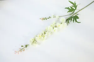 Artificial flower branch detail close-up, floral arrangement decoration prop, realistic design.