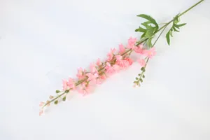 Close-up detail of artificial pink delphinium flower branch, ideal for wedding decor.