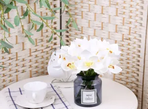 Artificial white orchid flower bouquet detail view, elegant home tabletop decor ornament.