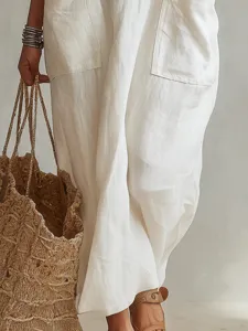 Detailed view of casual linen pocket garment with natural texture and woven straw bag.