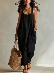 Detail shot of a black cotton linen maxi slip dress with pockets worn by model outdoors.