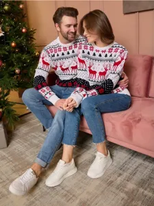 Cozy Christmas couple sweater detail featuring festive reindeer patterns in a warm holiday setting.