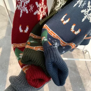 Close-up detail shot of winter Christmas knitted sweaters featuring festive snowflake patterns.