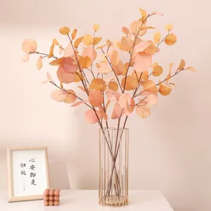Artificial autumn eucalyptus branches in metal vase for home decor and wedding floral design.