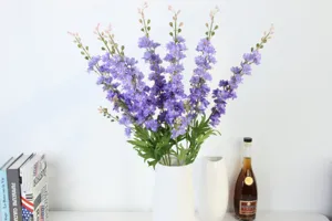 Artificial purple delphinium flowers bouquet in white ceramic vase for home decoration