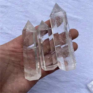 Gros plan détaillé de trois pointes de cristal de quartz transparent tenues dans la main.