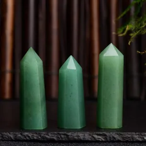 Close-up of natural green crystal pillars with smooth hexagonal polished surfaces and tips.