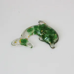Crystal resin dolphin detail view, featuring green stones and shiny gold foil flakes.