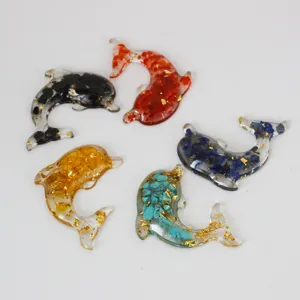 Close-up details of multi-color crystal resin dolphin accessories, sparkling gold foil.