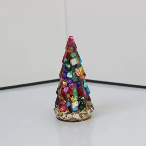 Vista detallada de la decoración de mesa de árbol de navidad de cristal con piedras de colores.