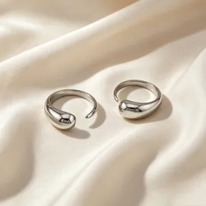 Gros plan détail de la bague ouverte goutte d'argent avec surface polie sur soie.