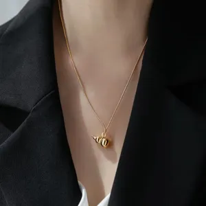 Detailed close-up shot of an elegant gold-colored gourd pendant necklace with a fine chain.