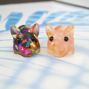 Detailed closeup view of cute handmade resin pig figurines featuring colorful stone and gold flakes.