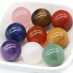 Close-up detail of multi-colored natural crystal gemstone spheres in a white display tray.