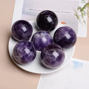Natural purple amethyst crystal sphere detail shot, polished gemstone home decor ornament.