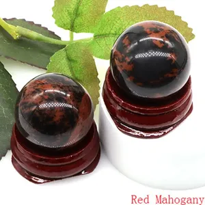 Red mahogany obsidian crystal ball home decor sphere with wooden base gemstone display.