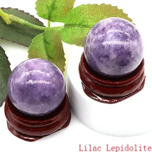 Natural lilac lepidolite crystal sphere detail view with wooden stand for home decor.