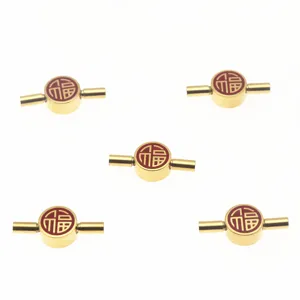 Close-up detail of golden stainless steel bracelet connectors with red Fu character.