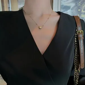 Close-up view of gold stainless steel heart pendant necklace featuring delicate chain.