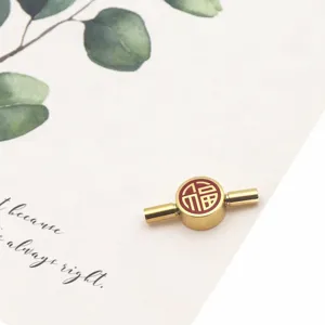 Detail view of the gold stainless steel DIY bracelet connector bead with a red Fu character.