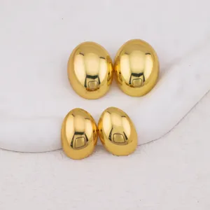Detailed close-up of glossy gold-plated oval stud earrings set, minimalist chic jewelry style.