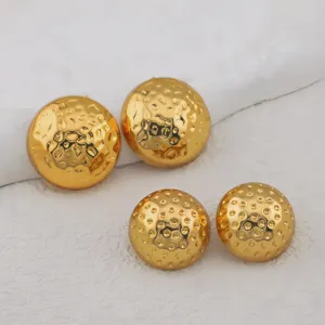 Detailed close-up of textured gold-plated spherical ball stud earrings, elegant and shiny.
