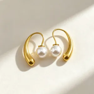 French retro pearl drop earrings detail shot, elegant gold hook design with smooth metal texture.