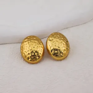Close-up of gold-plated oval hammered earrings, showing exquisite texture and details.