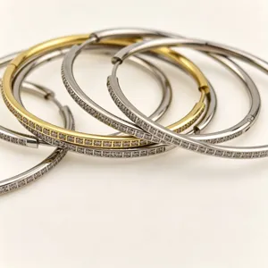 Close-up detail of luxury stainless steel diamond hoop earrings, elegant gold and silver tone.