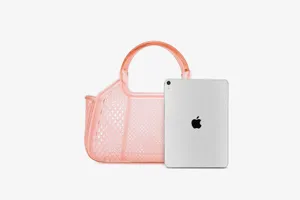 Detailed view of pink clear PVC jelly tote bag showcasing mesh pattern size scale with tablet.